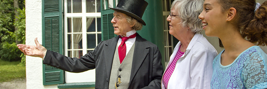Un acteur Sir John A Macdonald parle avec deux visiteurs.