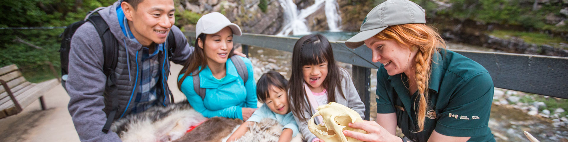 Une interprète de Parcs Canada donne des explications à une jeune famille au parc national des Lacs-Waterton. 
