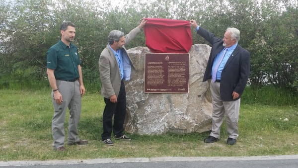 Commemorative plaque being unveiled by three man