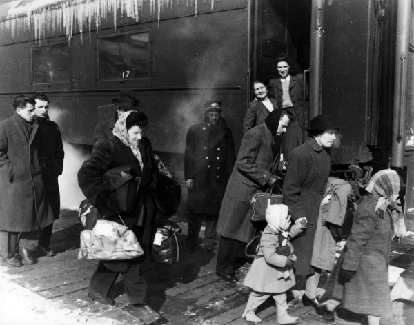 Historical photo of families walking along a train