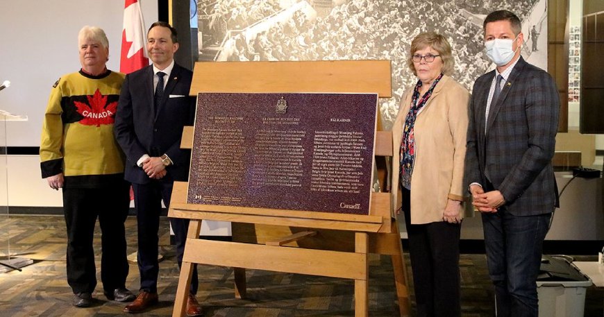 Four persons presenting a commemorative plaque