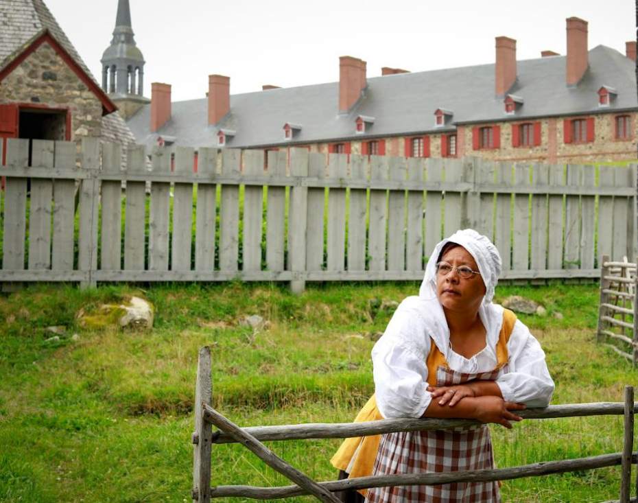 Une femme en vêtements historiques s'appuyant sur une clôture