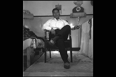 black and white image of a man sitting in a chair