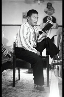 Image en noir et blanc d'un homme assis et lisant