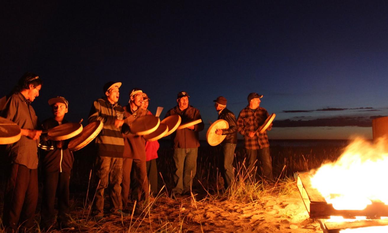 Photo of a group of people around a fire