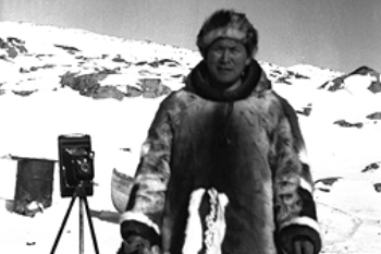 Black and white photo of a man waring fur clothes in a winter background