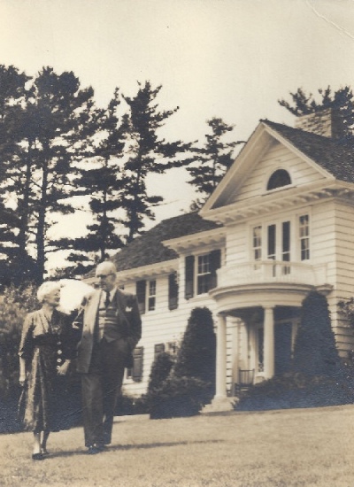 Photo historique d'une femme et d'un homme se tenant debout devant une maison blanche