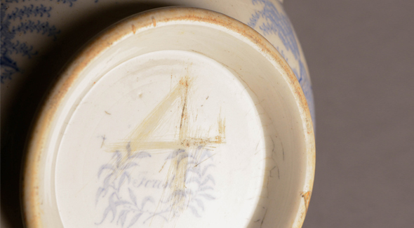 Markings on the bottom of a blue and white bowl.