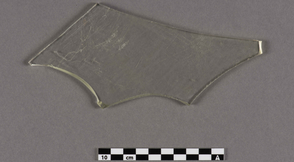 A piece of clear irregular shaped glass rests.