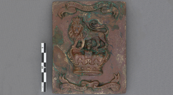 Une plaque rectangulaire brune et verte avec des détails.