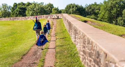 Guide costumé accompagné d’enfants costumés montent la garde près d’un rempart des fortifications de Québec