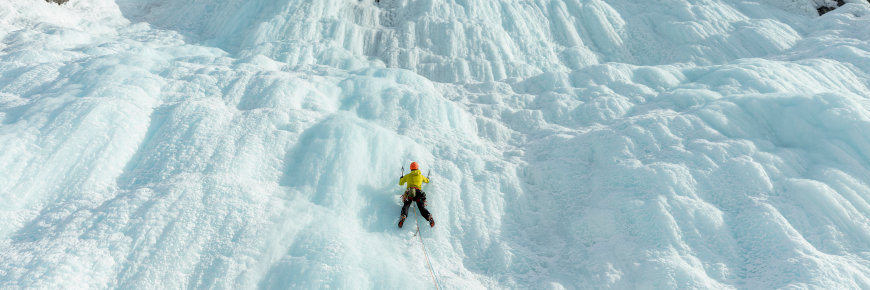 An ice climber on a frozen waterfall.