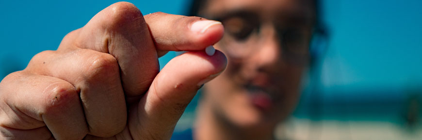 A person holding up a microplastic pellet. 