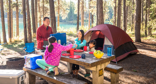 A family enjoys breakfast at their campsite at Two Jack Lakeside Campground in Banff National Park.