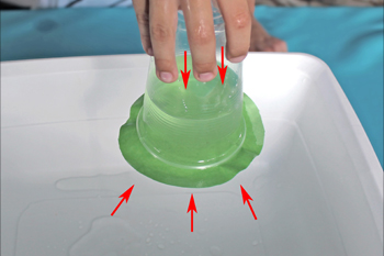 Vue rapprochée du cercle de papier qui retient l’eau à l’intérieur du gobelet à l’envers