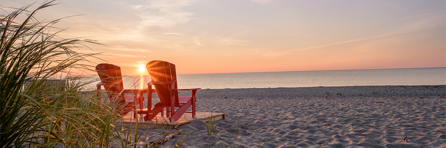 Red chairs at Kellys Beach during sunrise, Kouchibouguac National Park 