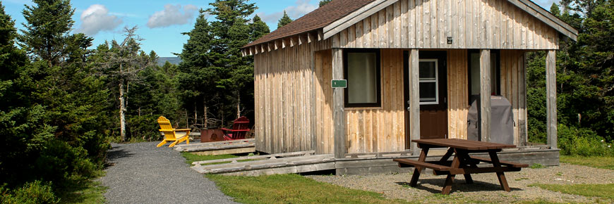 A rustic cabin that caters to visitors on the autism spectrum with a picnic table.