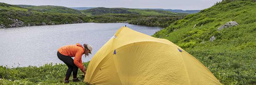 A camper sets up her tent at Gros Morne National Park.