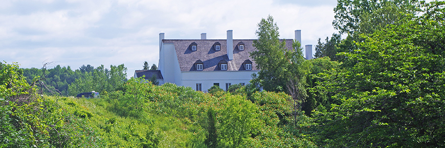 La Grande maison des Forges-du-Saint-Maurice entourée par la forêt