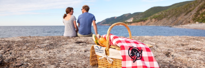 A couple with a picnic basket on a rocky shore at Kejimkujik.