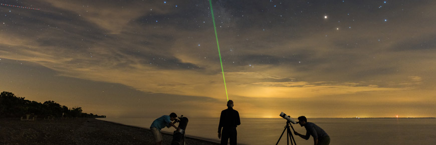 Des visiteurs observent le ciel à l’aide de télescopes à la plage West.