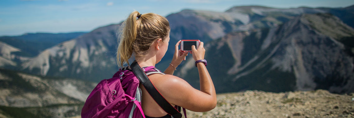 A woman takes a picture of the scenic Sulphur Skyline view.
