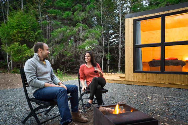 A couple is enjoying a campfire in front of their MicrOcube