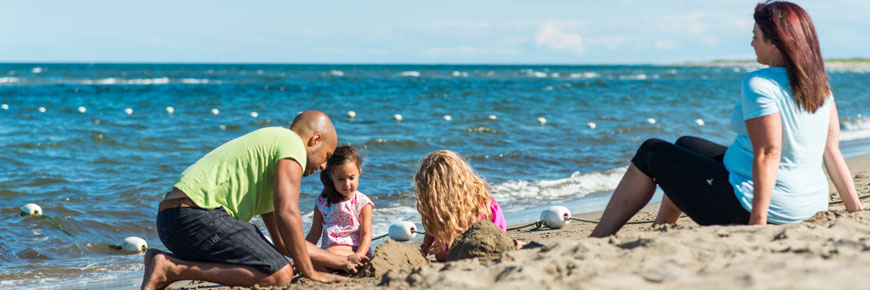 A family playing in the sand at Kouchibouguac National Park.