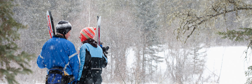Visitors stand with their cross-country skis in the park.