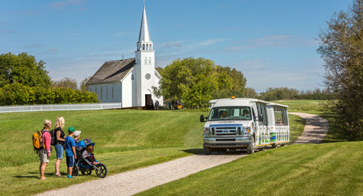 A shuttle picks up a family by the church. 