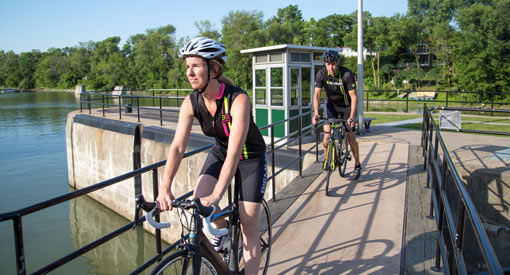 Des cyclistes à vélo le long du canal de Saint-Ours par une journée d'été ensoleillée.