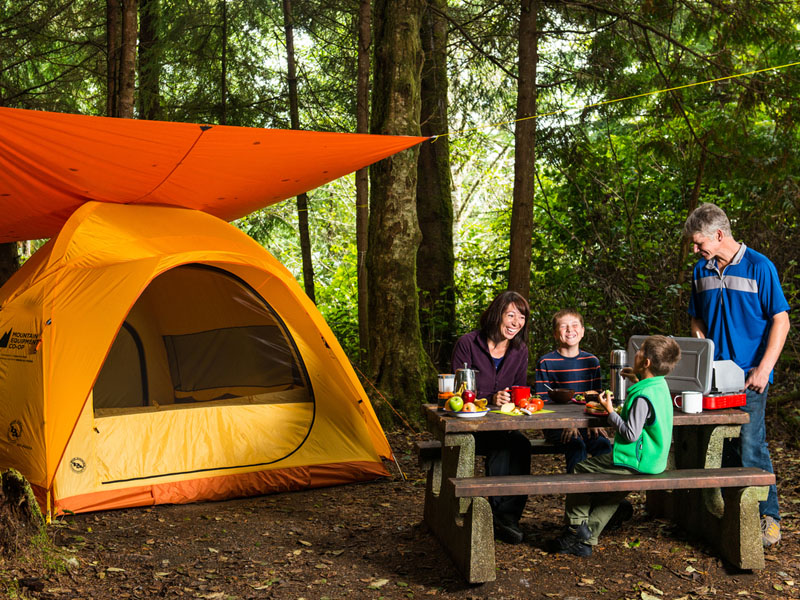 Une famille sur un emplacement de camping équipé.