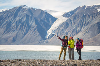 Hikers standing near water, watching for birds and animals at Tanquary Fiord