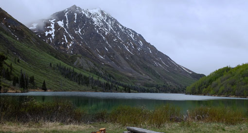 Un lac au pied d'une montagne avec un sommet enneigé.