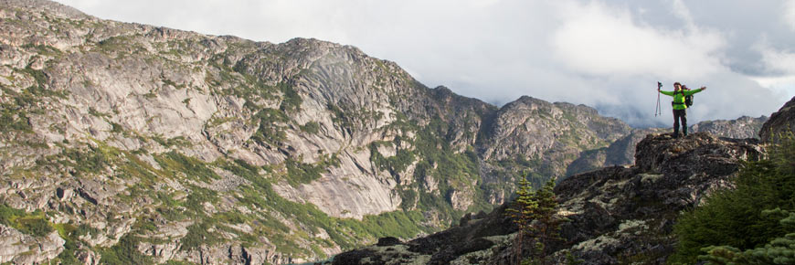 Randonneur sur la Piste-Chilkoot devant un paysage montagneux.