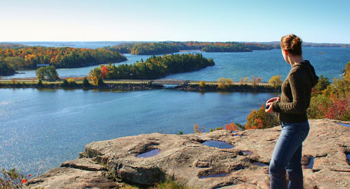 A woman admires the islands and the St. Lawrence River from a lookout on the Lookout Trail.