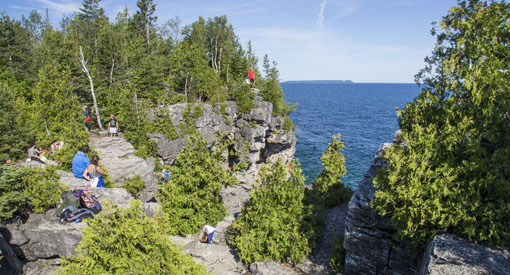 Visitors take in the view of Georgian Bay atop cliff near the enterance to the Grotto.