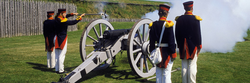 Interpreters dressed as soldiers fire a cannon at Fort Wellington National Historic Site