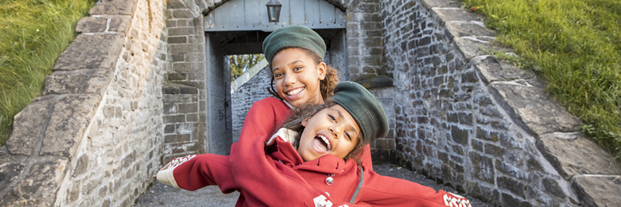 Two children smile in soldier costumes at Fort Wellington