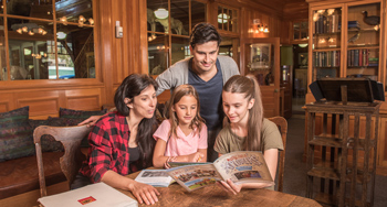 A family enjoys the Xplorers activity booklet inside the museum's reading room