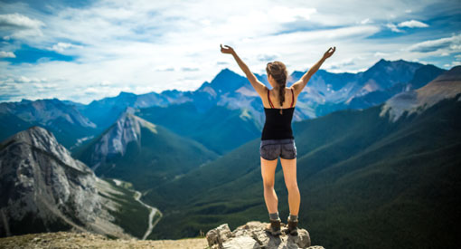 A young woman enjoys the peak of Sulphur skyline with her arms outstretched