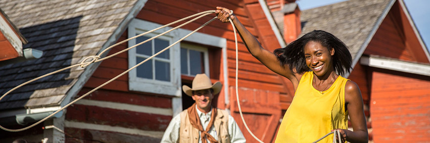 A young woman tries roping a replica steer
