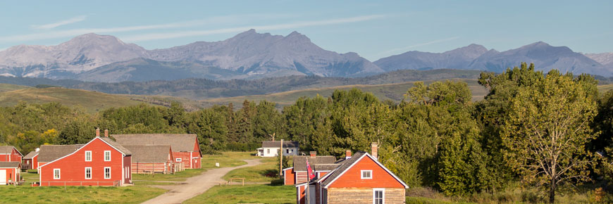Panoramic view of the buildings of Bar-U-Ranch National Historic Site and the Rockies.
