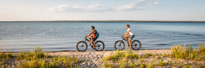 Visitors ride fat bikes along the beach on South Lake Trail. 