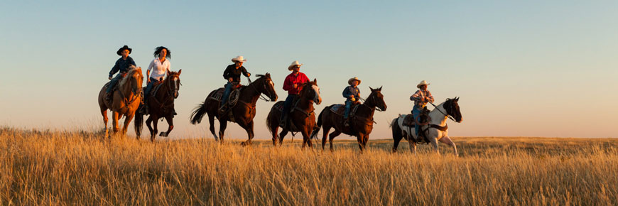 Un groupe de gens à cheval dans les prairies