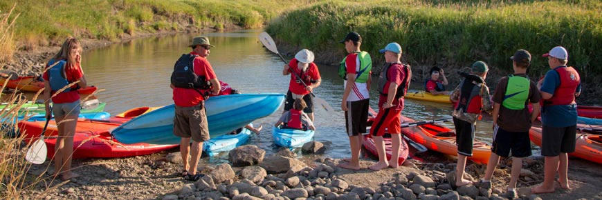 Un groupe de visiteurs se préparent à faire du kayak sur la rivière Frenchman dans le bloc Ouest du parc national des Prairies. 