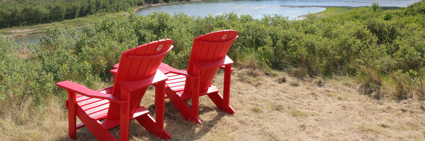 Une famille sur les chaises rouges devant la vallée de la rivière Saskatchewan-Sud.