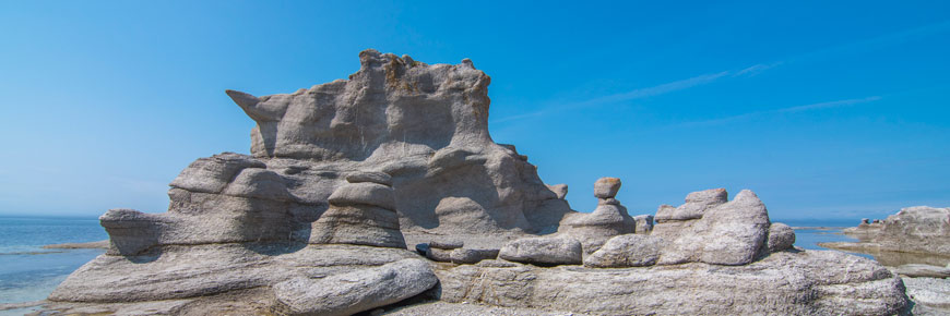 Monoliths that look like a castle on a pebble beach.
