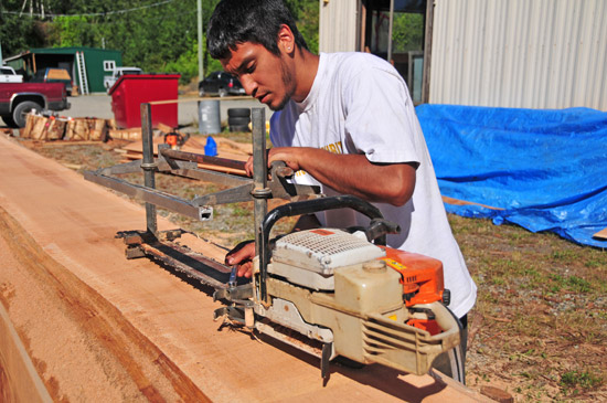 Carving assistant Tyler York uses an Alaska mill to shape the log