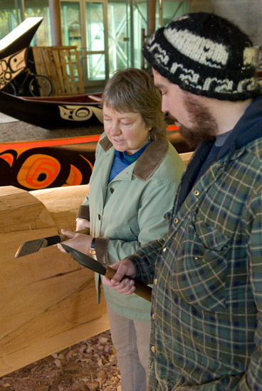 Jaalen montre ses outils de sculpture à un visiteur.